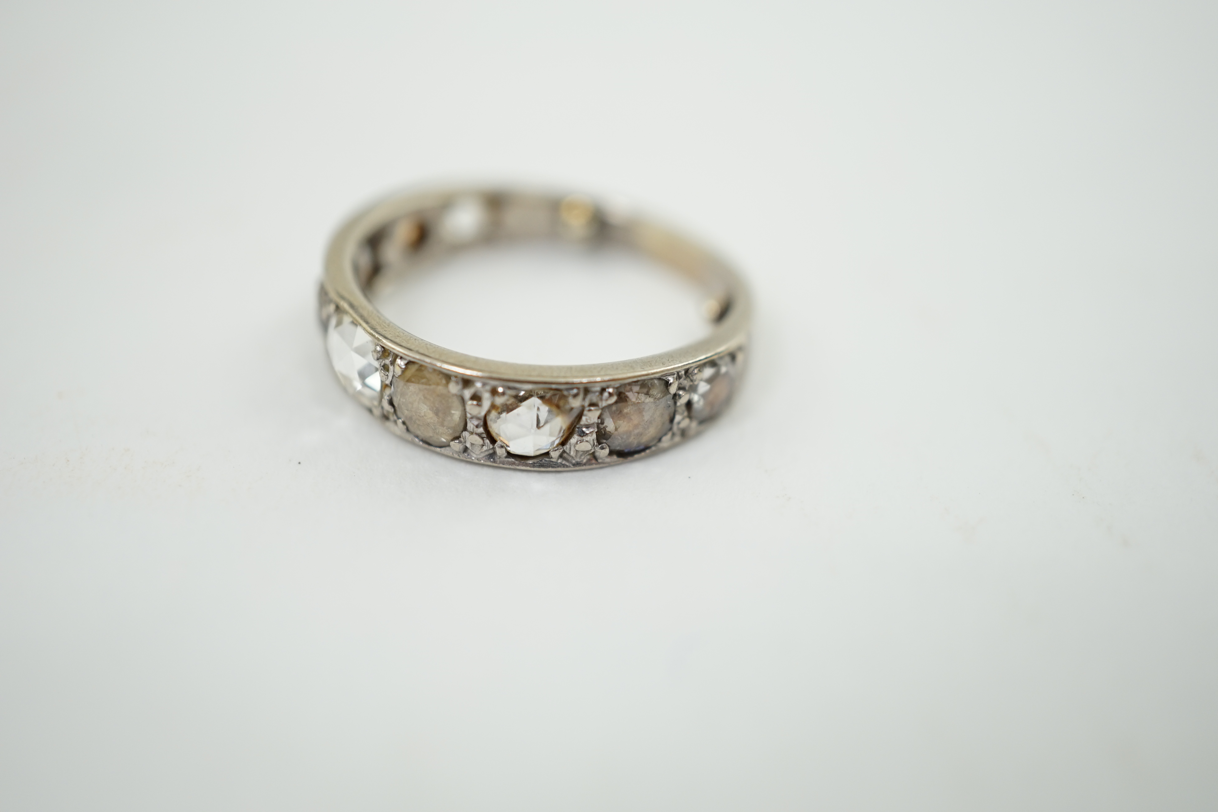 A white gold and nine stone graduated rose cut diamond set half hoop ring